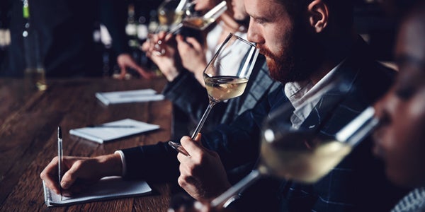 bar patrons drinking wine with man writing notes