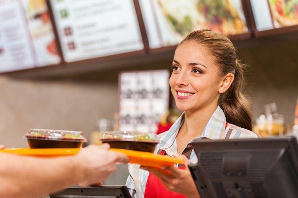 Happy woman fast food server at counter - QSR - quick service restaurant
