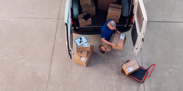 Delivery driver sorting through boxes